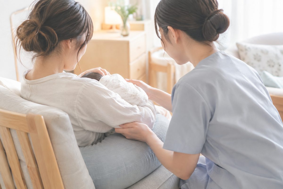 助産師が授乳の姿勢をサポートしているイメージ